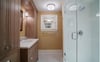 Just off of the bedroom, an ensuite bathroom with identical cabinetry to the kitchen, tiled floors, and large shower.