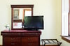 A large dresser and flat screen TV help the bedroom feel more like home.