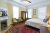 In the primary bedroom, youll find another decorative hearth, mirrored armoire and a carved wooden headboard above the kingsize bed.