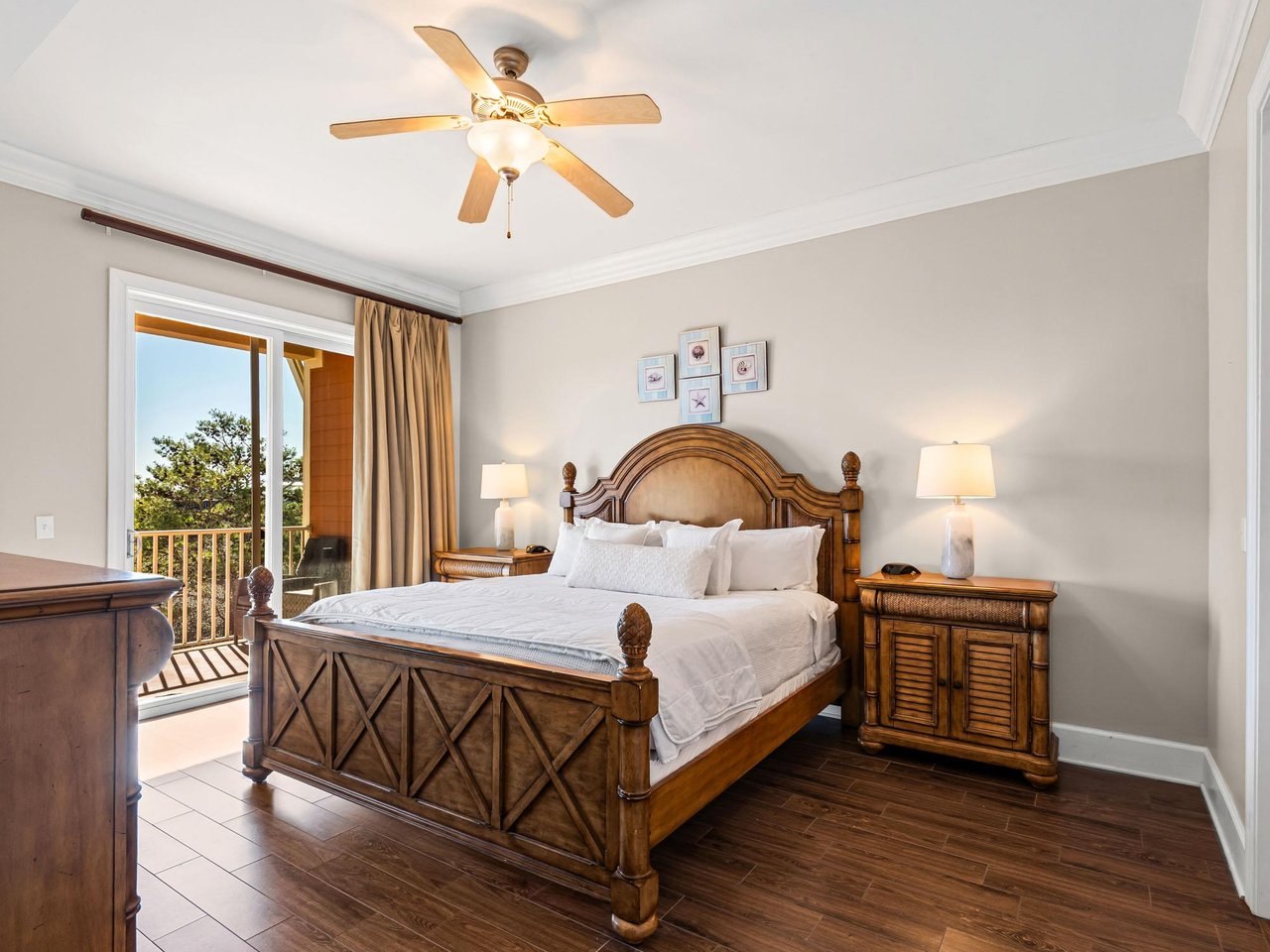Sleep peacefully in this elegant bedroom featuring rich wood furnishings, crisp linens, and balcony overlooking lush greenery.