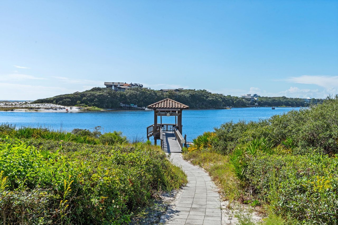 2191163 A Path Leading To A Building On A Hill By A Body Of Water