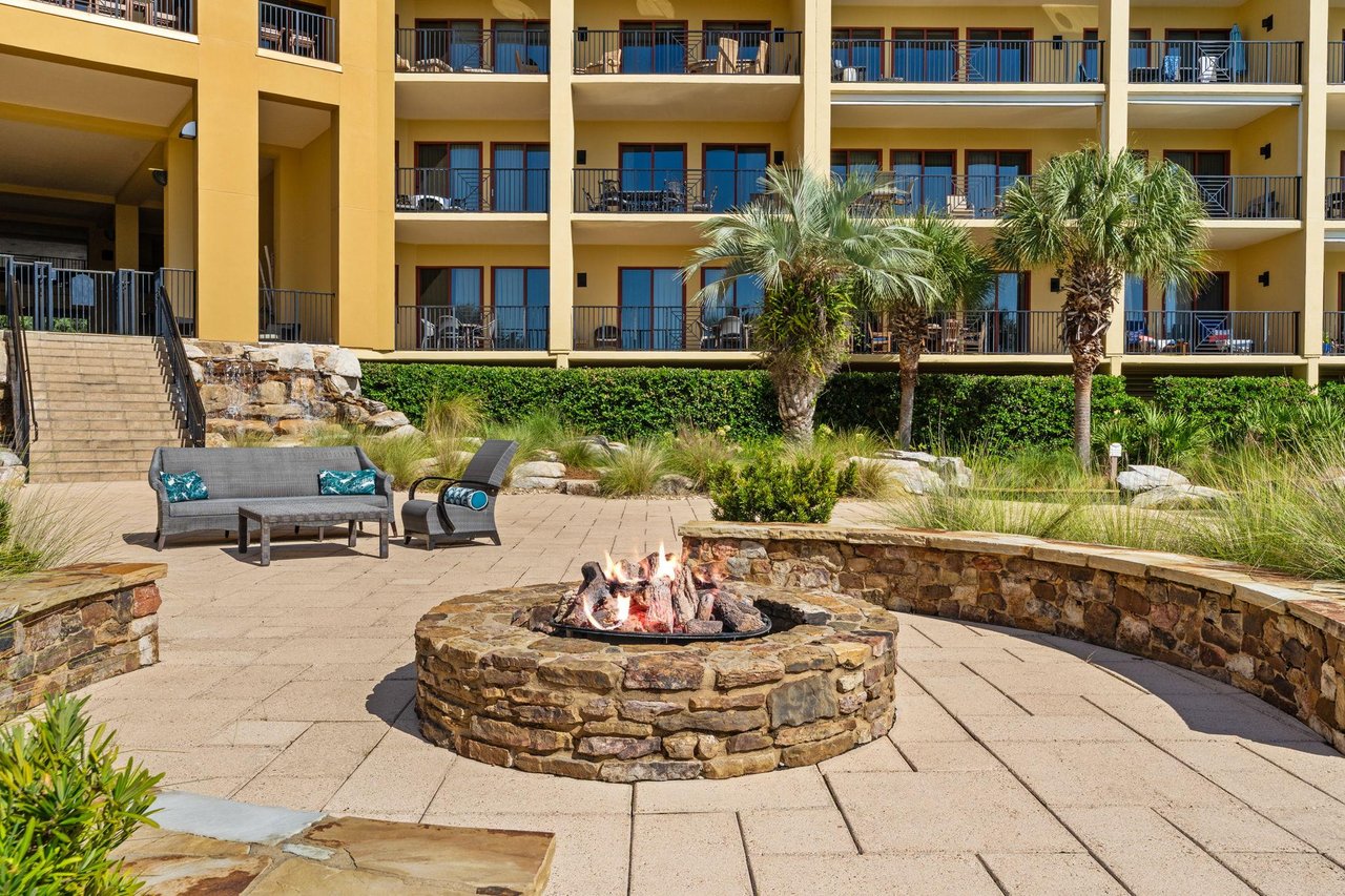 2191183 A Courtyard With Benches And Trees In Front Of A Building