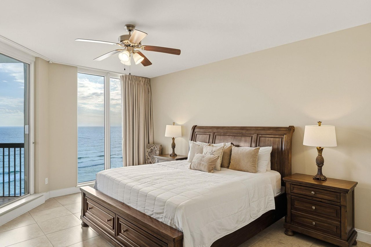 Bedroom 1 Wake up to stunning beach views in this serene bedroom with private balcony access.