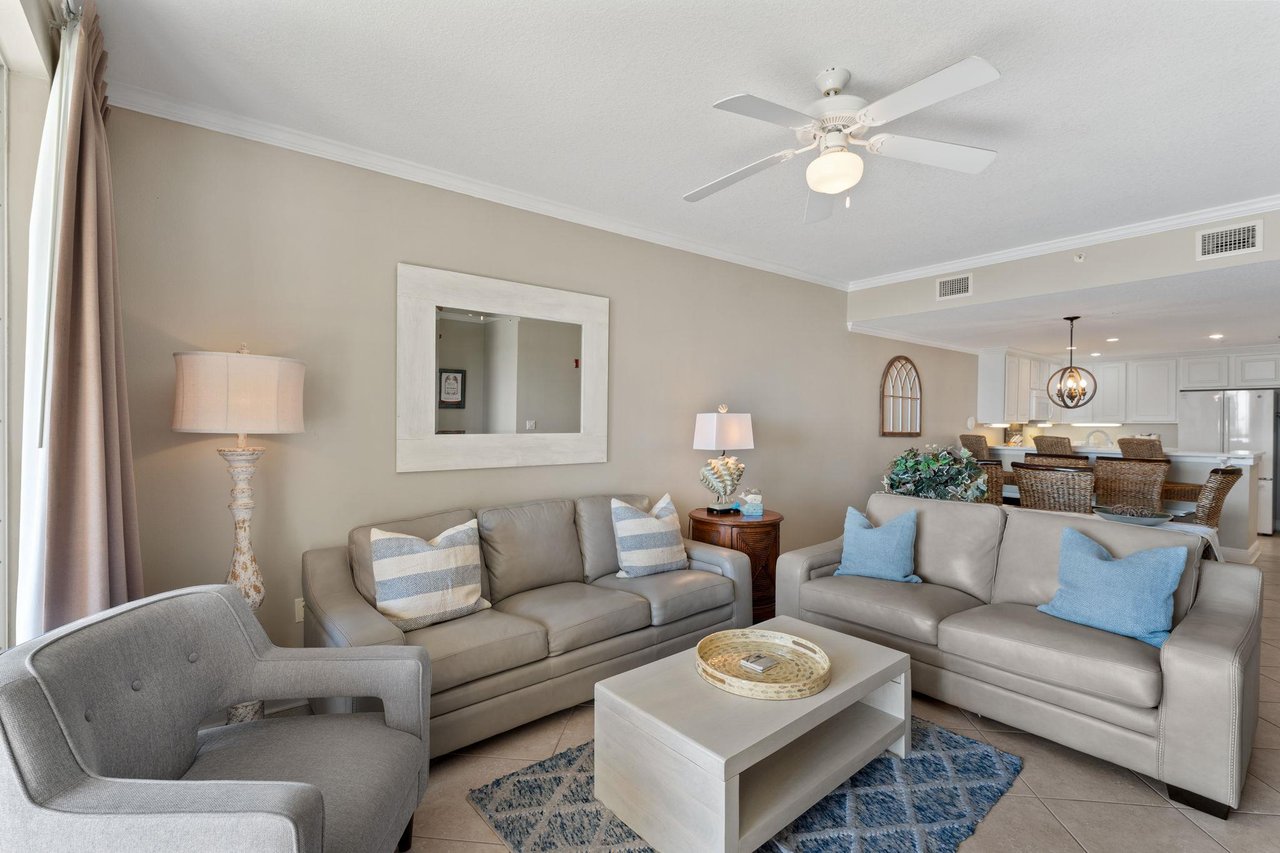 Youll love unwinding in this sophisticated living space, where plush gray sofas and coastal blue accents create your perfect retreat.