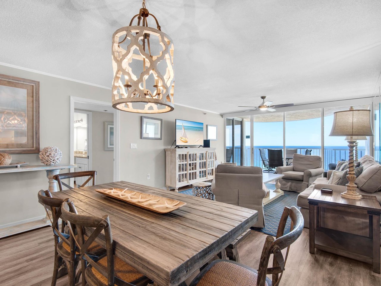 Picture yourself unwinding in this coastalchic space, where natural light flows through floortoceiling windows framing stunning gulf views. The open layout invites you to gather around the rustic d