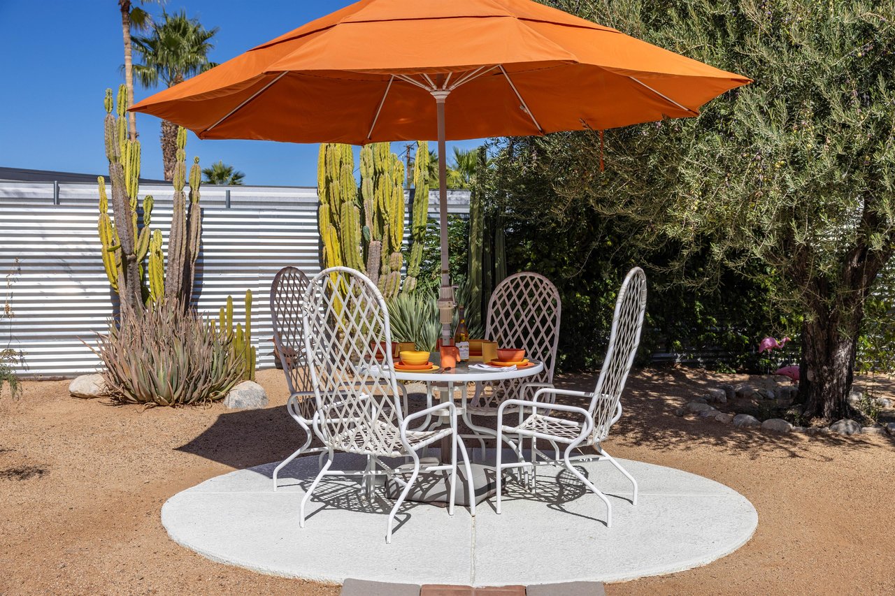 Outdoor dining for four under the orange umbrella