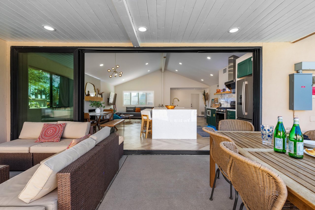 The kitchen flows into the outdoor covered dining and seating areas