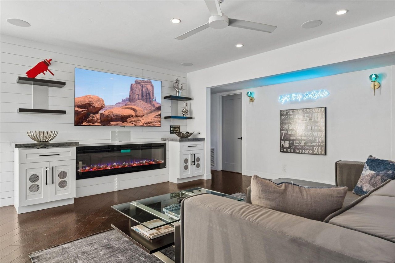 Modern interior with electric fireplace, flatscreen TV, and ample seating.
