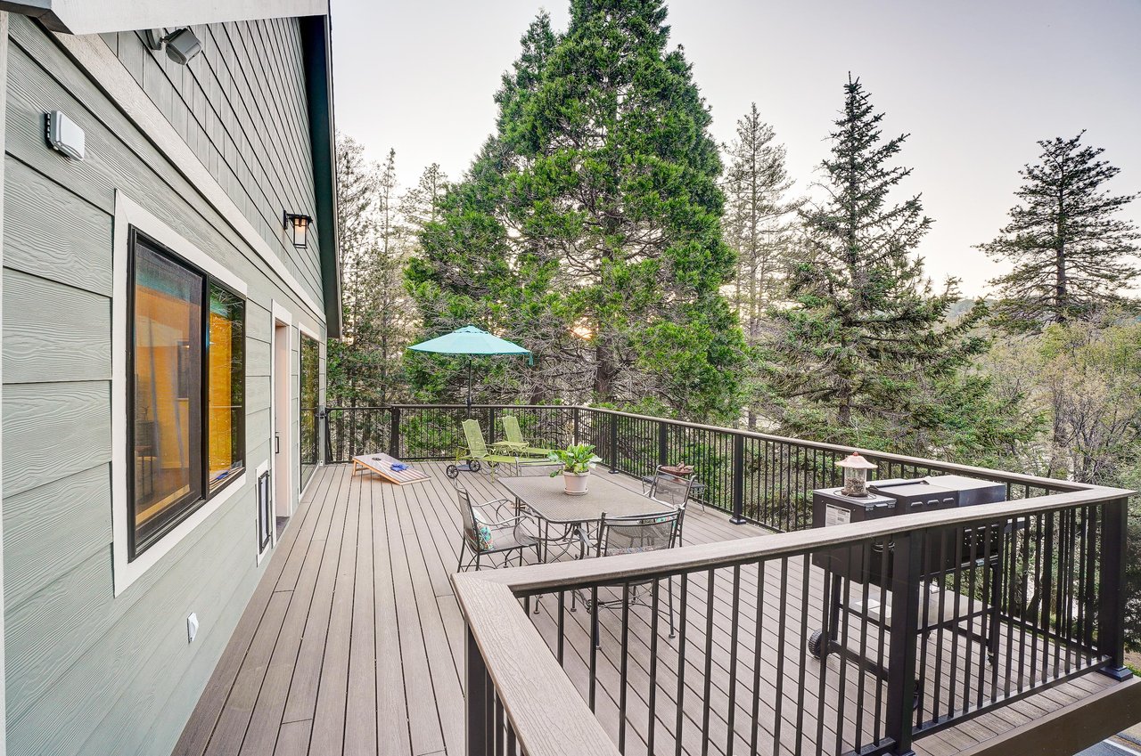 Spacious deck with mountain and forest views, outdoor games, BBQ, and deck seating.