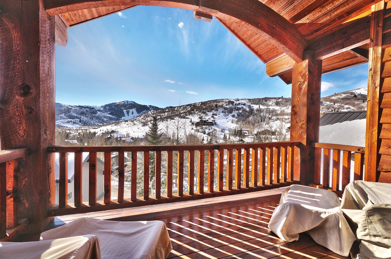 A private covered patio off the first main bedroom with Deer Valley Resort views, and wood deck, railing, ceiling and beams.
