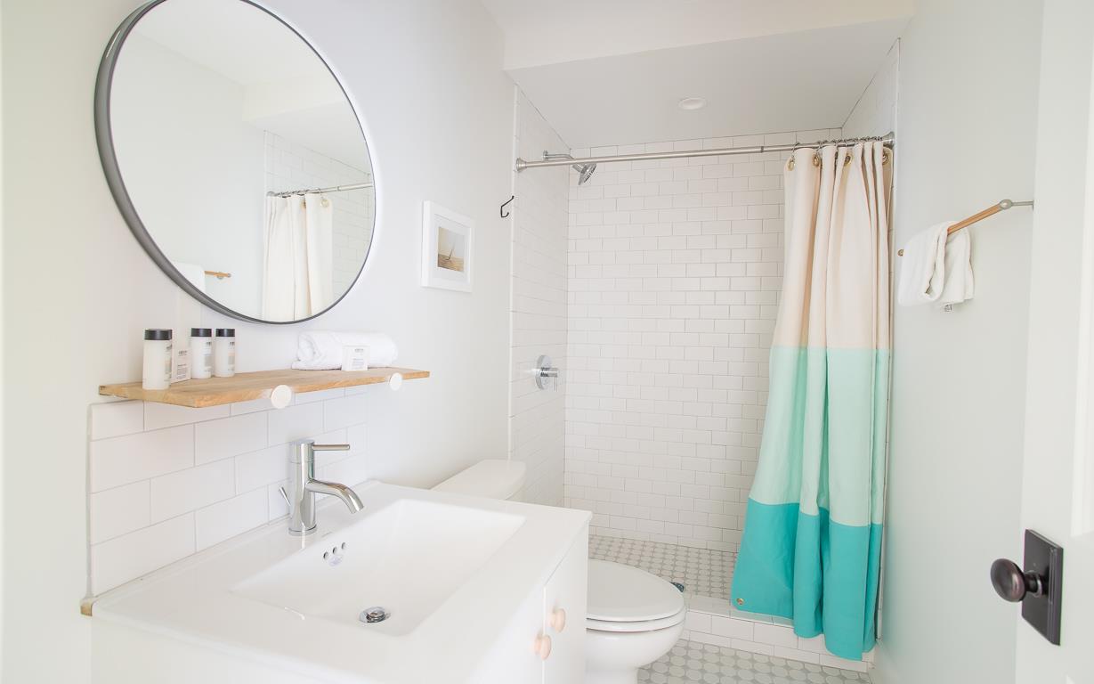 The bath features a standing shower with subway tile and caddy.