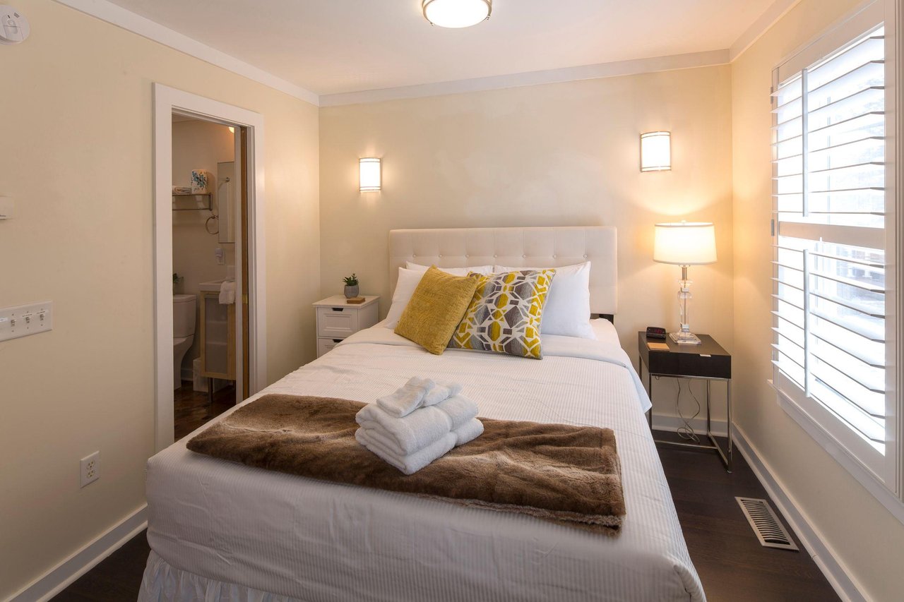 A comfortable queen size bed is tucked away in the corner.