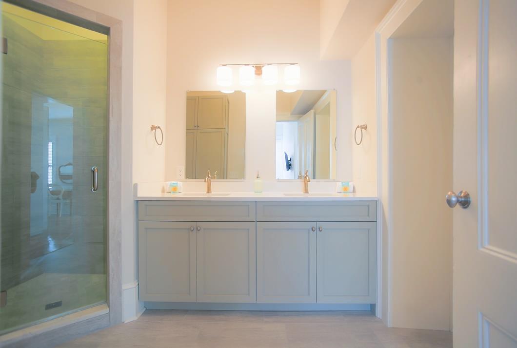 The en suite to the primary bedroom has a stand up shower and two vanities.