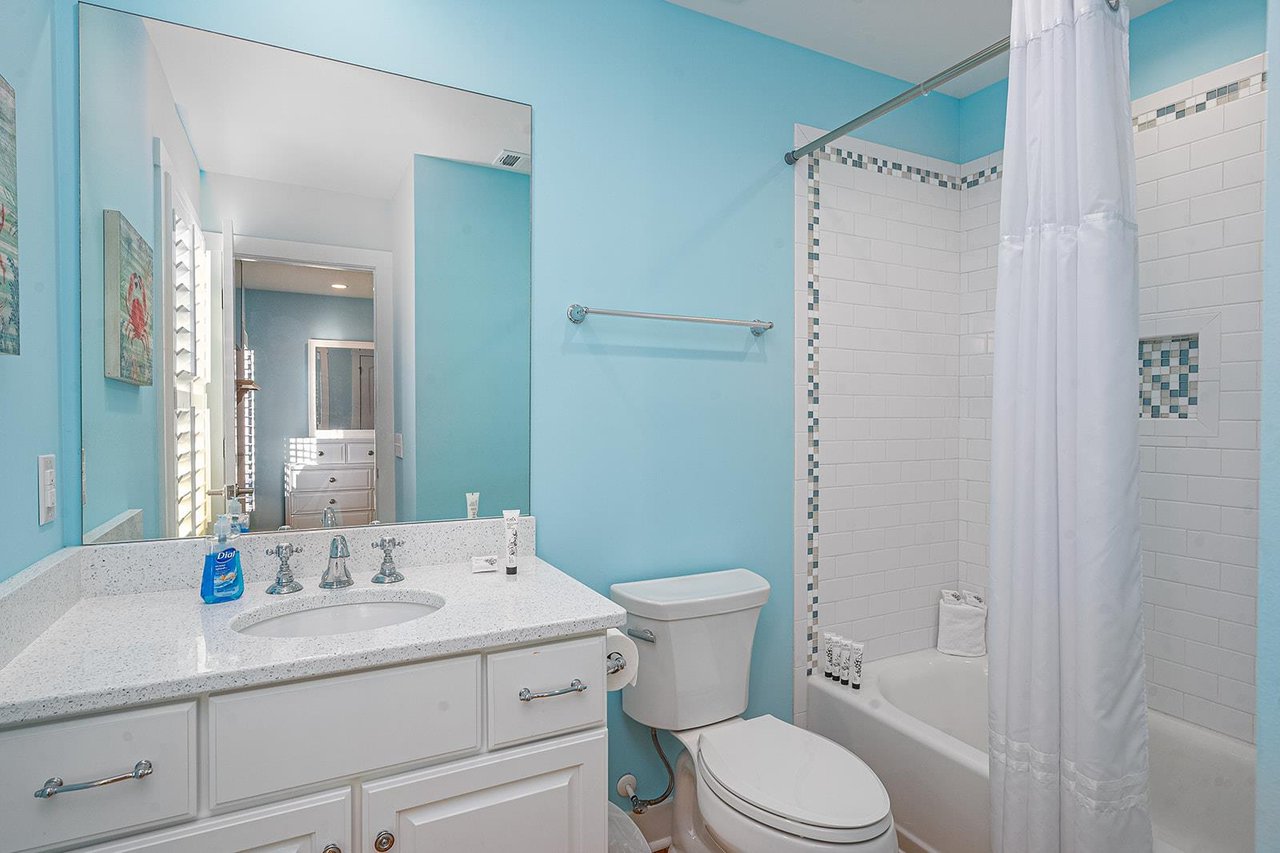 The ensuite bathroom offers a large vanity and a tubshower combination.