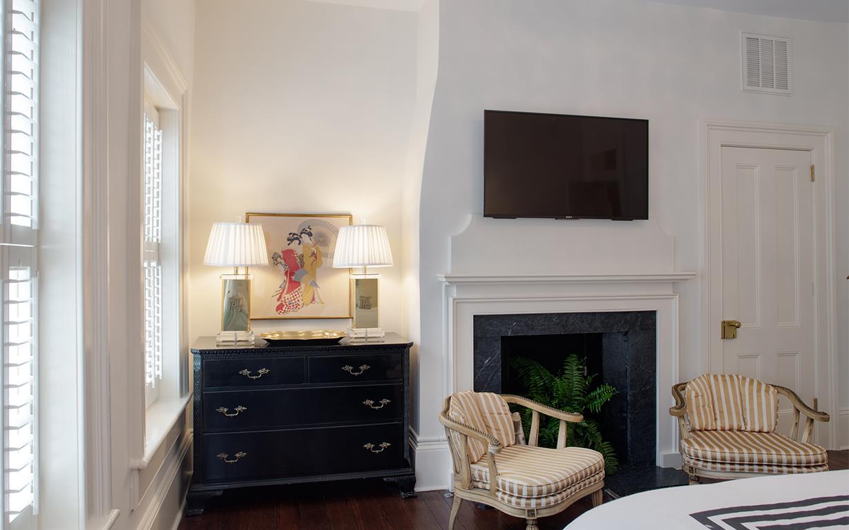 A large flat screen television sits just above the fireplace Enjoy your favorite shows while nestled in bed.