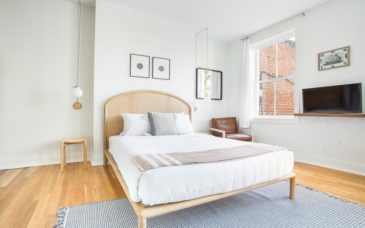 The Queen size bed is dressed with plush linens.