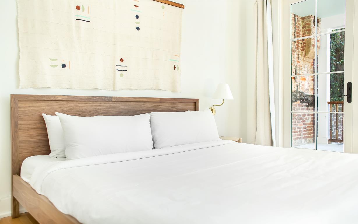 A handpainted canvas art piece hangs above the bed.