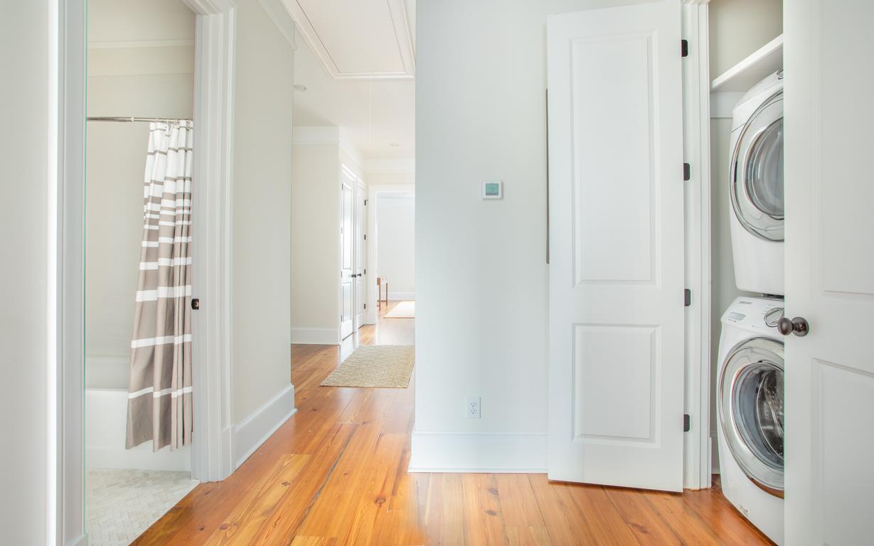 A stacking washer and dryer is in the hall.