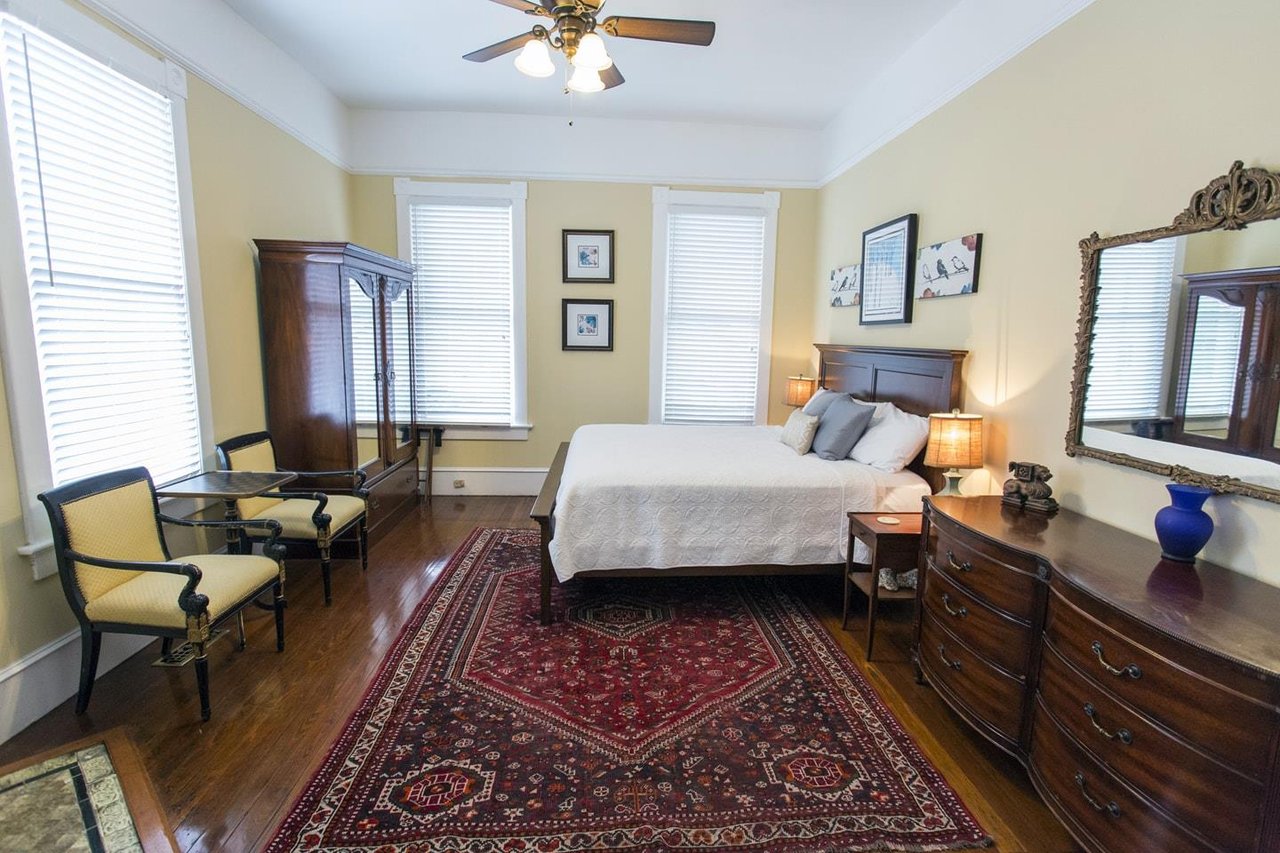 The original hardwood floors extend from the living room, through the classic pocket doors and into the primary bedroom.