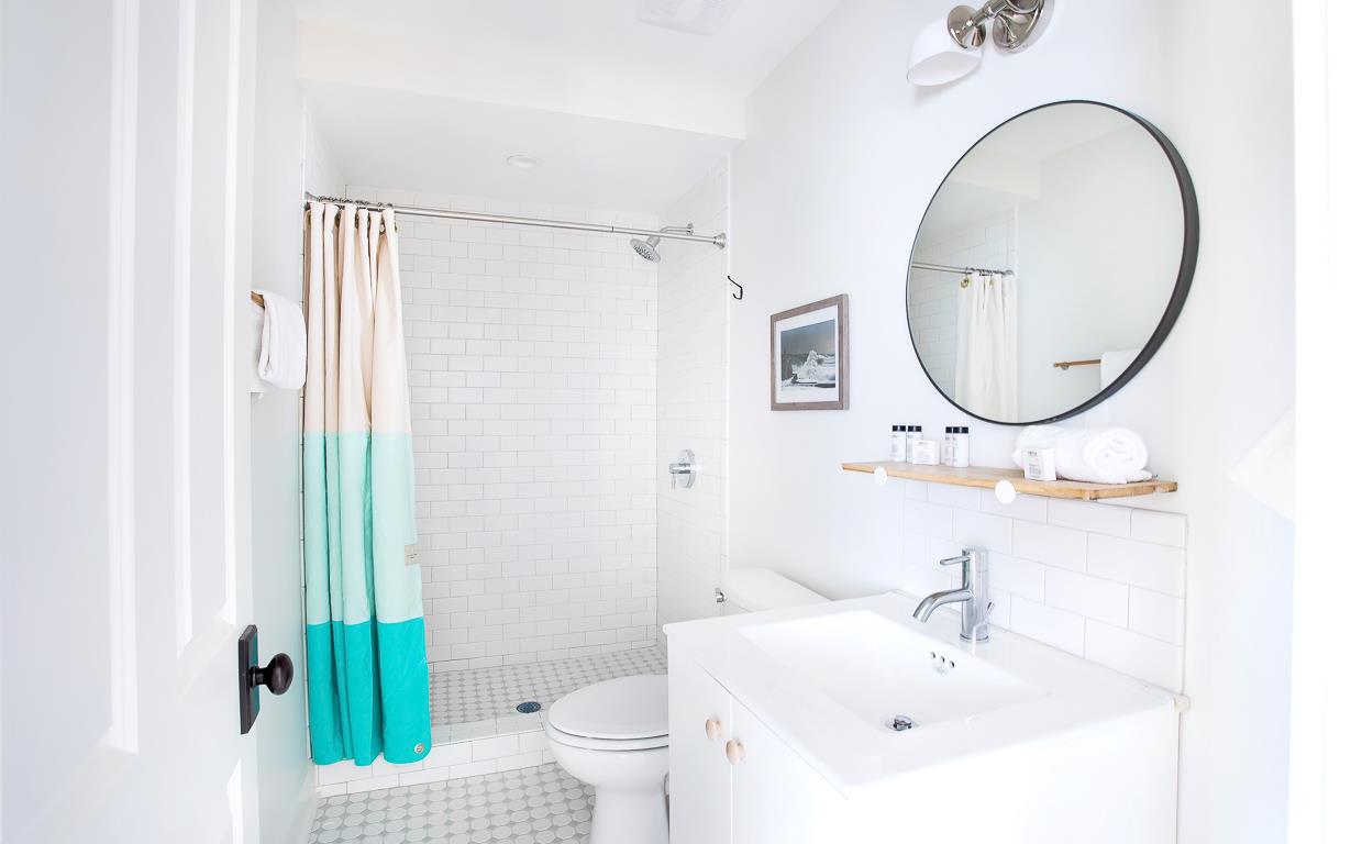 The bath features a standing shower with subway tile and caddy.