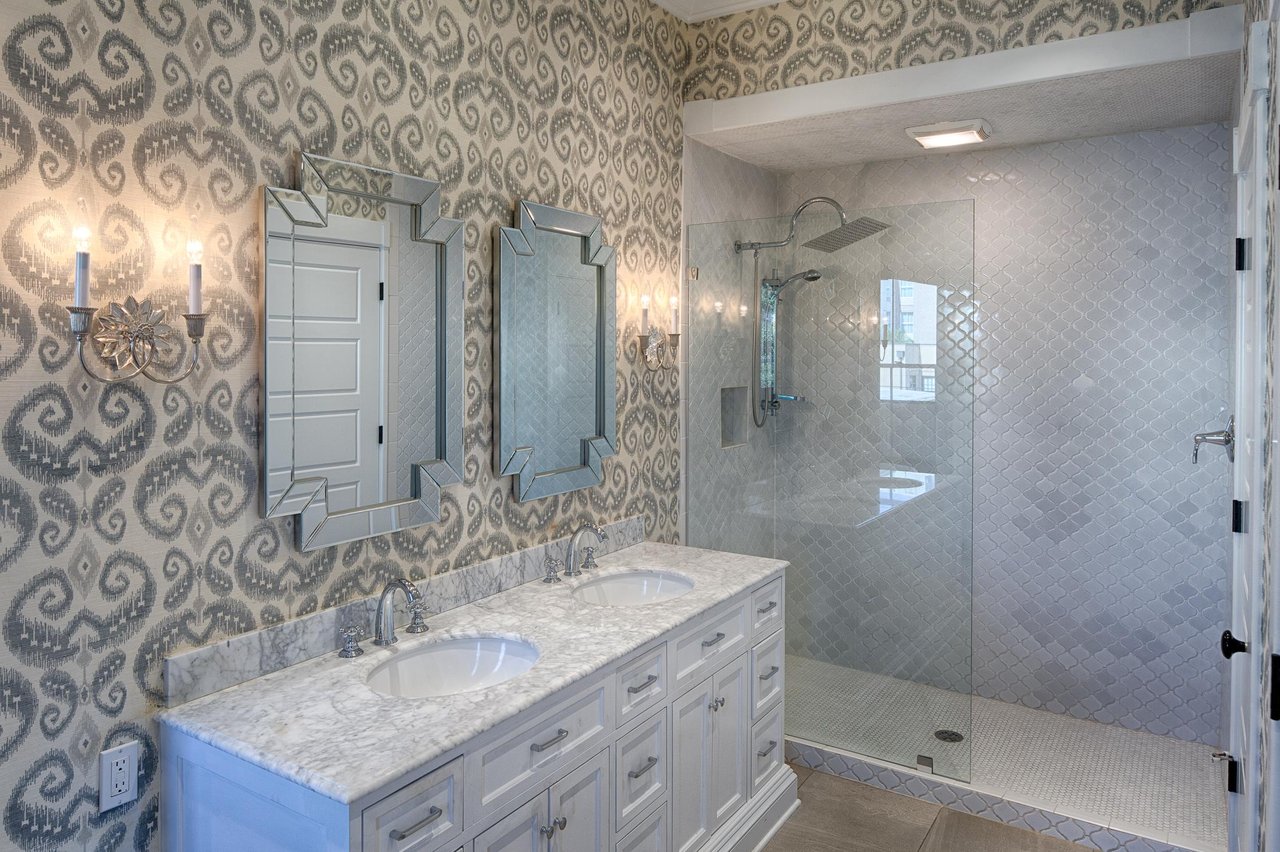 The walkin shower has custom, handlaid tile, and a large rainfall style shower head.