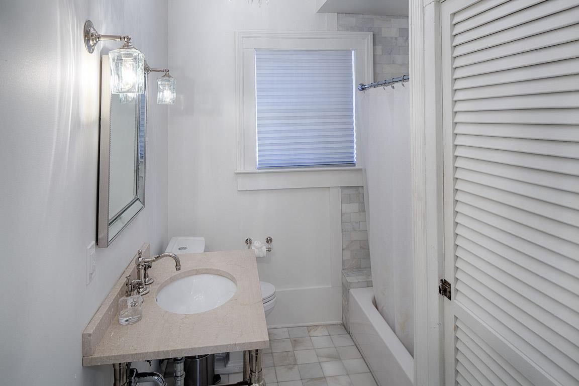 The first bath has a wide vanity and tubshower combo.