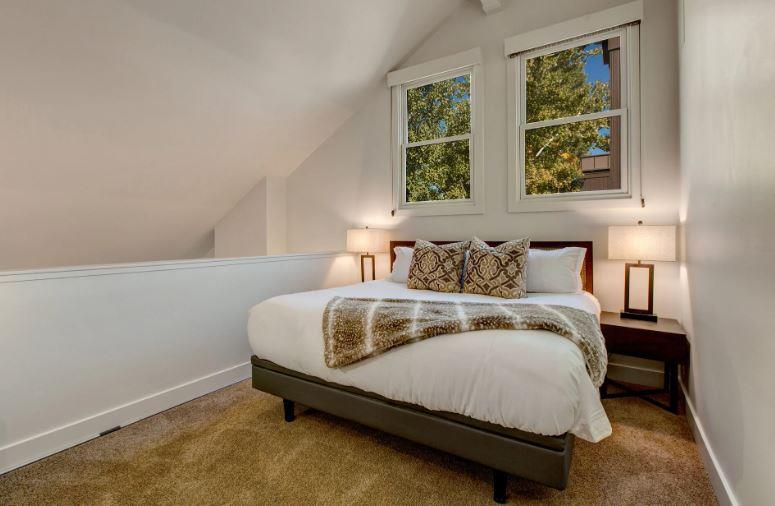 Elegant upstairs loft bedroom offering a king bed, private ensuite bathroom, and a cozy sleeping nook with a doublesize futon