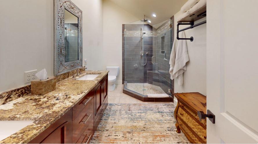 Elegant upstairs bathroom featuring a sleek, modern shower and refined finishes