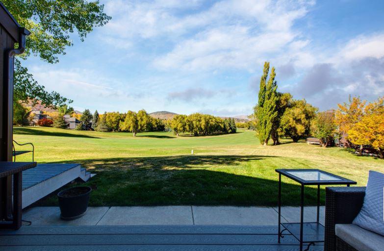 Expansive private deck with BBQ grill and stylish outdoor furnishings, offering breathtaking panoramic views of the golf course and resort area.