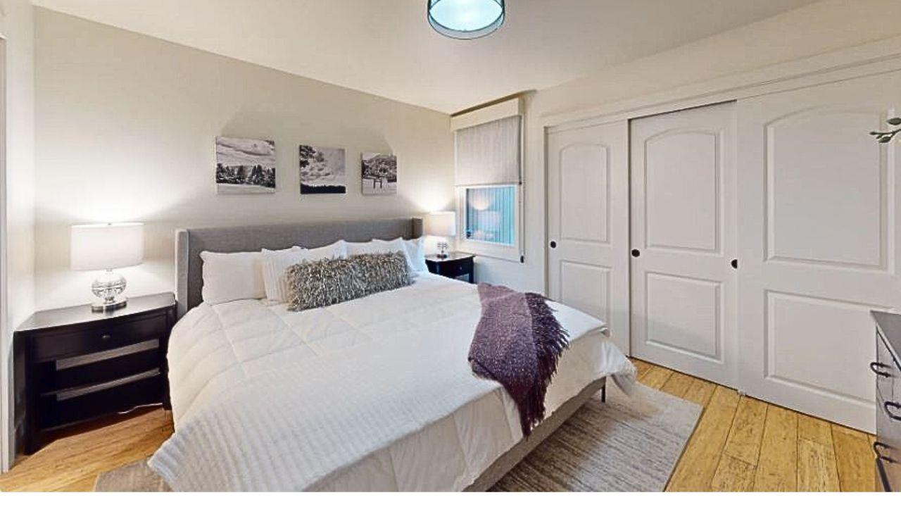 Luxurious downstairs master suite featuring a king bed and a private ensuite bathroom.