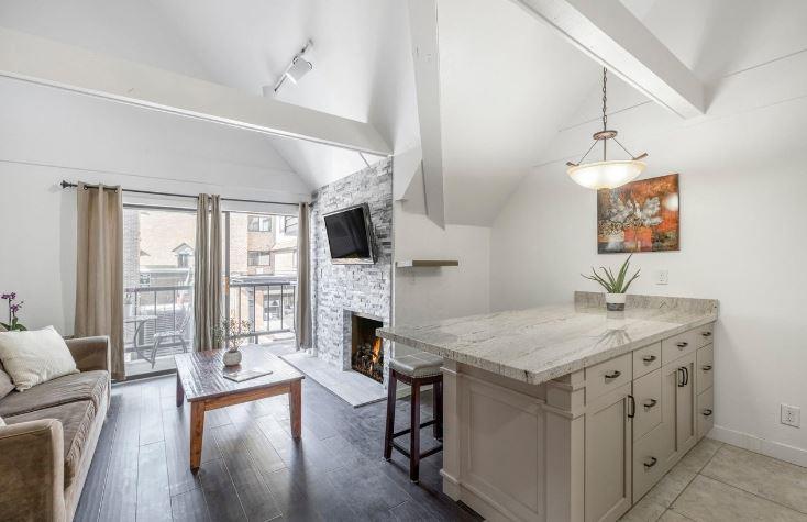 Bright, airy living spaces with a cozy fireplace and private balcony await at Lodge at Mountain Village 303 — your skiinskiout home base at Park City Resort.
