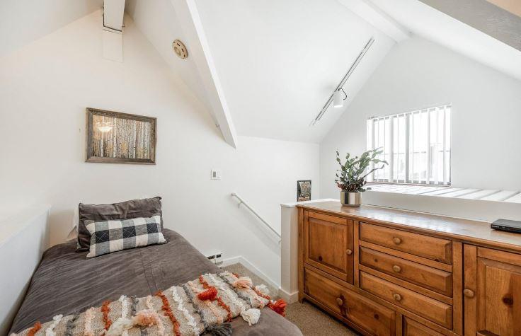 Room for everyone in the charming upstairs guest bedroom at Lodge at Mountain Village 303, featuring a queen bed, twin bed, and ceiling fan — your skiinskiout Park City Resort getaway.