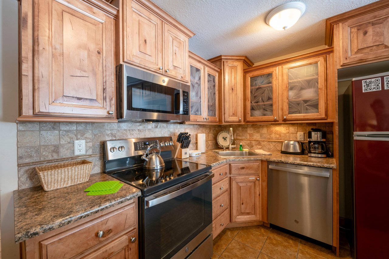 The fully equipped kitchen at Park Avenue 211 features stainless steel appliances, granite countertops, and plenty of space to prepare your favorite meals.