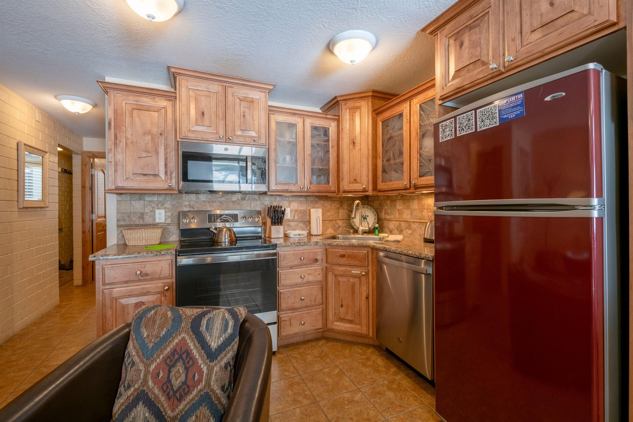 Stainless steel appliances, granite countertops, and warm wood cabinetry make the kitchen at Park Avenue 211 a welcoming spot to cook and gather.