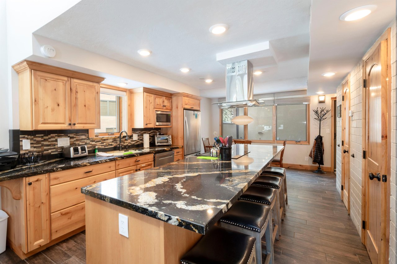 Pull up a stool at the oversized granite island in the kitchen at Park Avenue 235 — the perfect spot for morning coffee, casual meals, or aprèsski snacks.