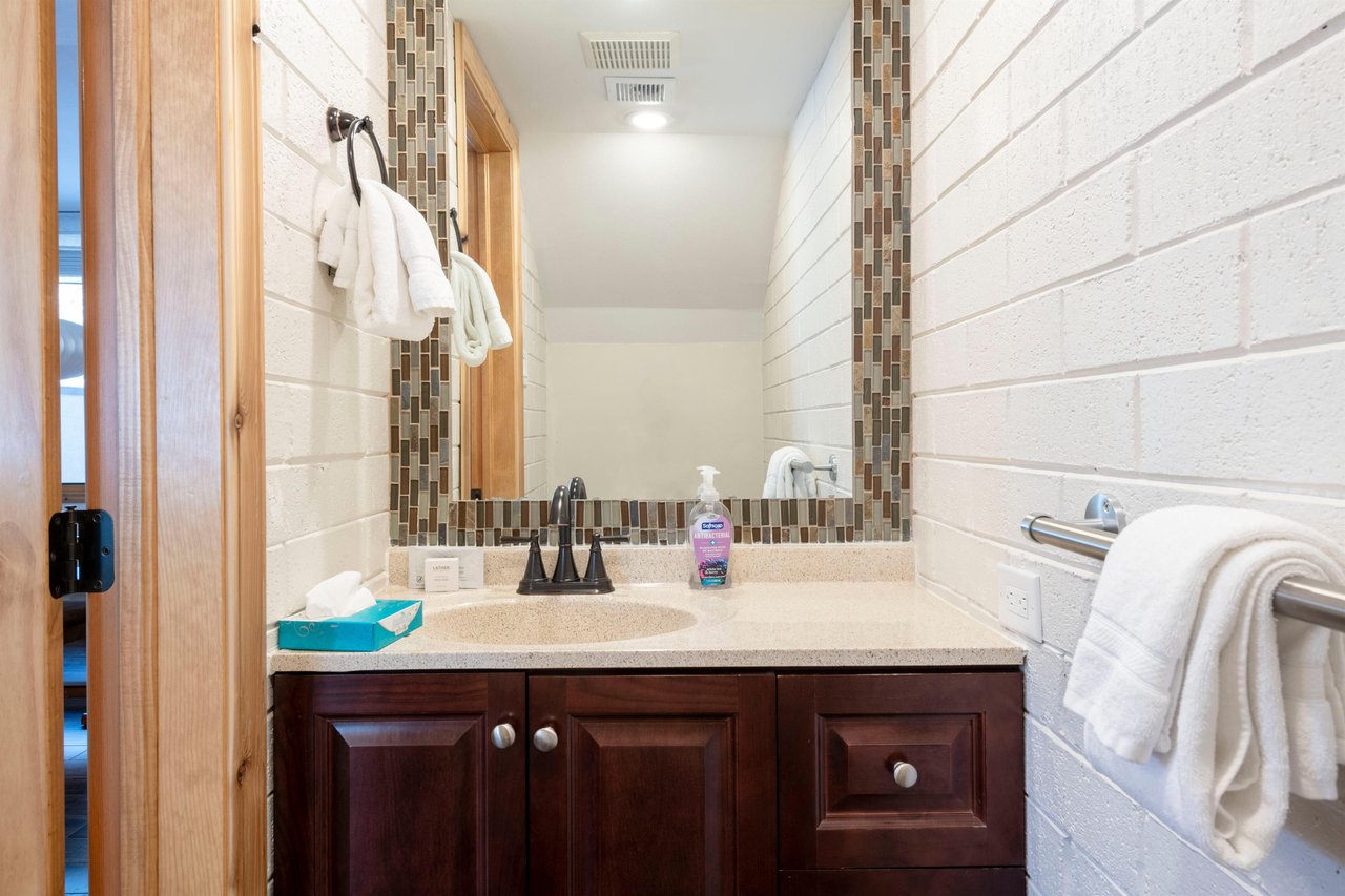 A stylishly updated half bath on the main level of Park Avenue 235 adds everyday convenience for guests and entertaining.