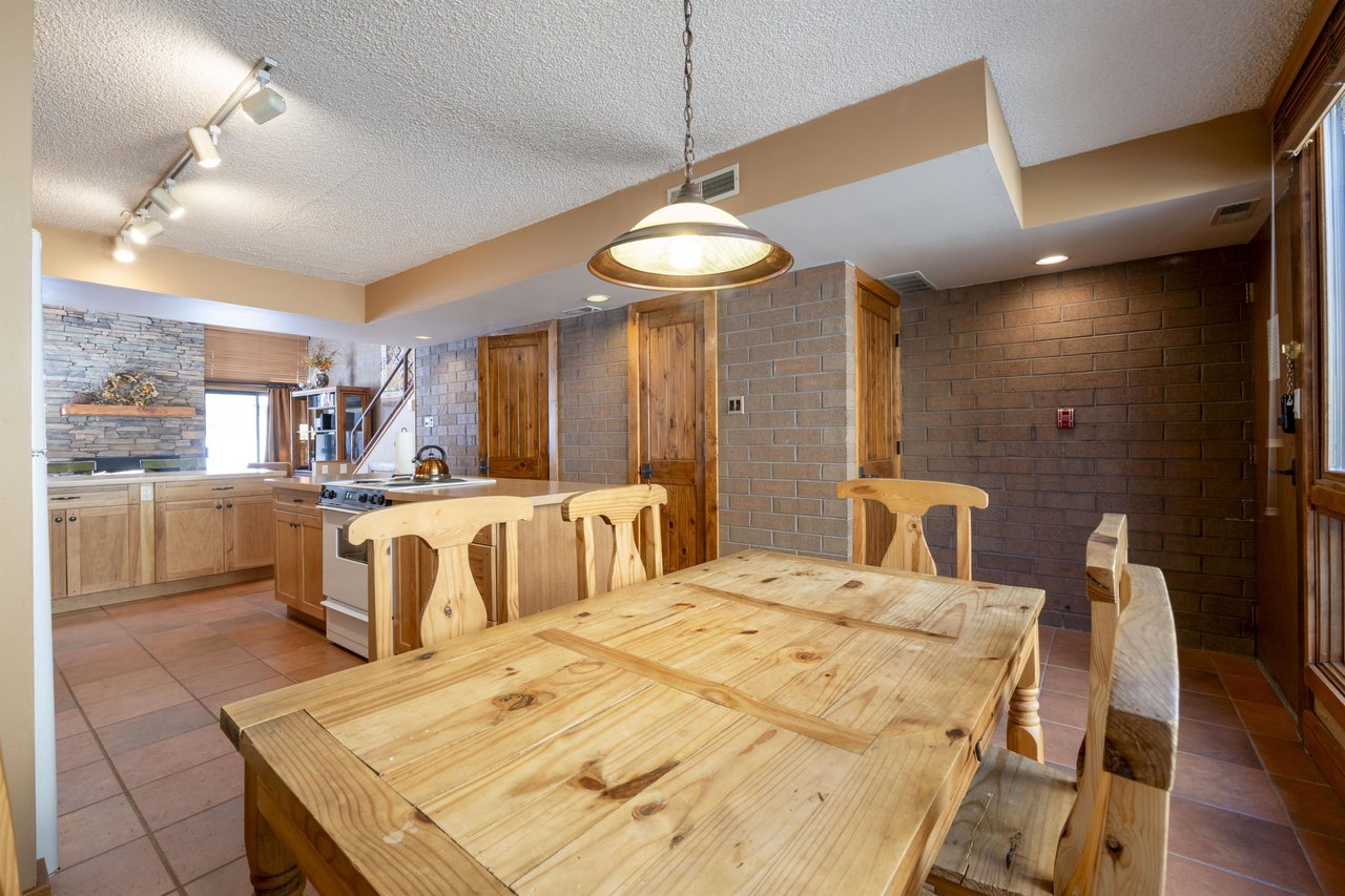 Gather around the rustic wood dining table at Park Avenue 224 — plenty of seating, an easy connection to the kitchen, and the kind of space that makes every meal feel relaxed.