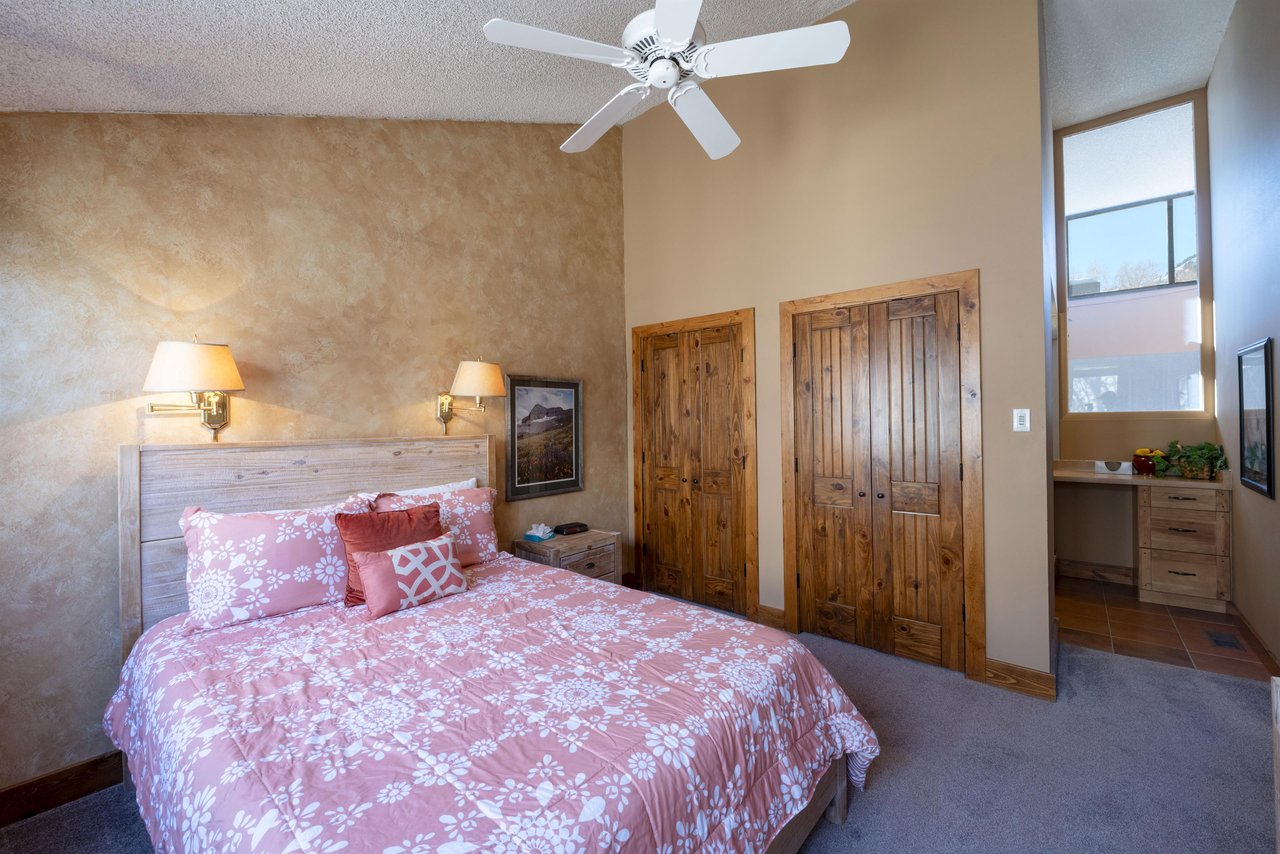 Rest easy in the queen bedroom at Park Avenue 224 — warm tones, a ceiling fan, and a cozy, wellappointed feel make this a welcoming retreat after a full day in and near Park City, Utah.
