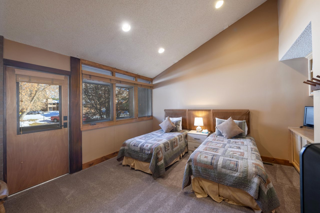 Two twin beds, a TV, and builtin storage make this bedroom at Park Avenue 224 a practical and comfortable space for younger guests during your Park City lodging stay.