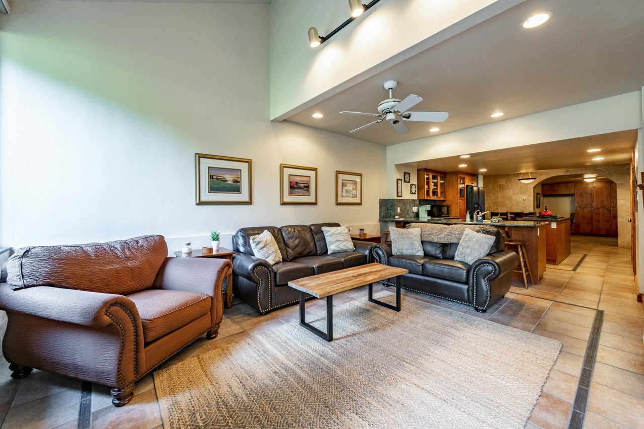 The spacious and wellappointed living area at Park Avenue 245 flows seamlessly into the kitchen, offering an open and comfortable layout perfect for groups enjoying a Park City lodging getaway.