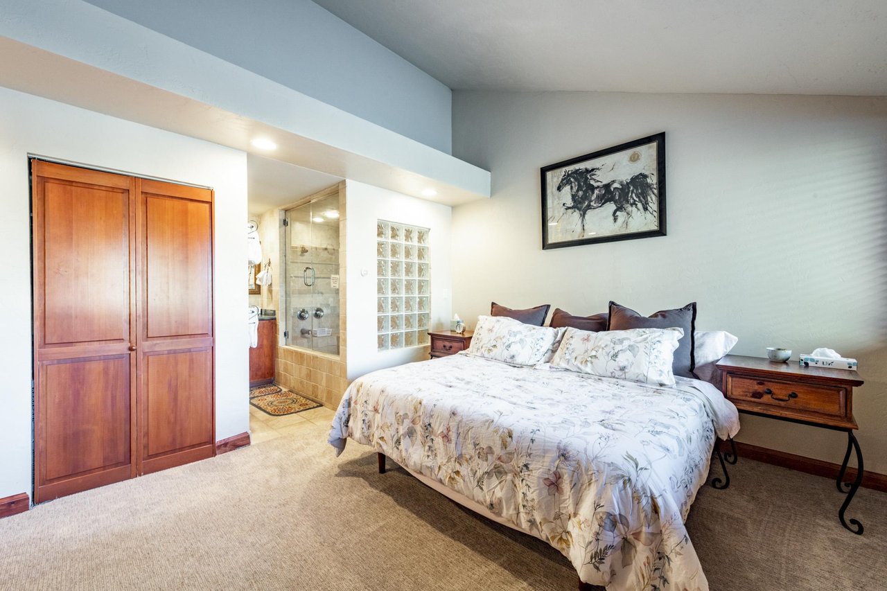 The elegant primary suite at Park Avenue 245 features a plush king bed, soft neutral tones, and a beautifully appointed ensuite bathroom — a luxurious touch that elevates this Park City condo rental 