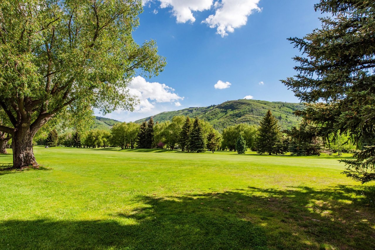 The view from the back patio at Park Avenue 267 stretches across lush golf course fairways to dramatic mountain peaks — an unbeatable backdrop that defines the best of Park City condo rentals on the g