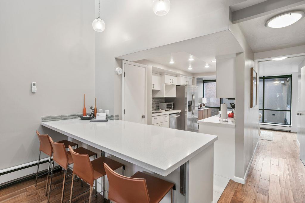 The sleek and modern kitchen at Park Avenue 296 features a generous quartz breakfast bar, perfect for casual dining and gathering. Clean lines and contemporary finishes make this one of the most styli