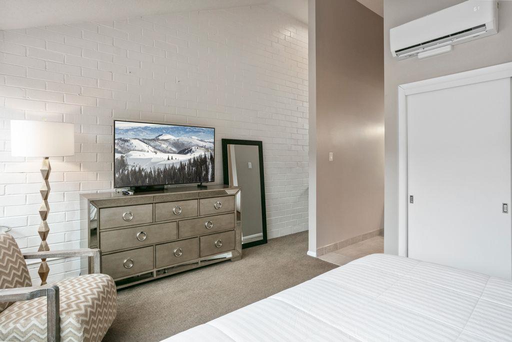 Every comfort is accounted for in the elegant primary bedroom at Park Avenue 296. From the glamorous mirrored dresser to the flat screen TV, the thoughtful touches throughout this Park City vacation r