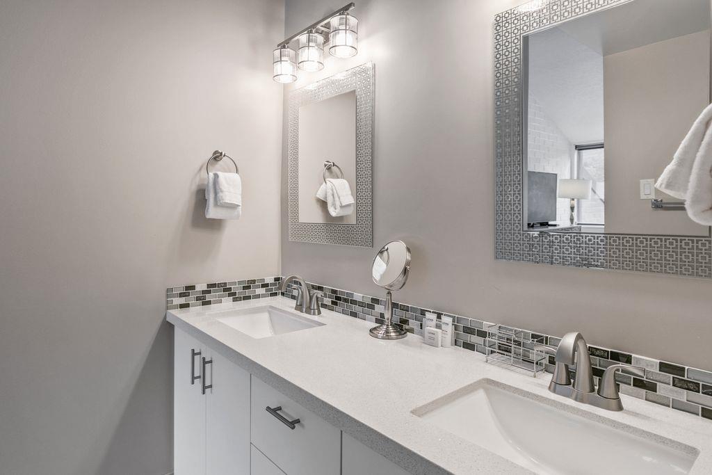The stunning primary bathroom at Park Avenue 296 features a double vanity, quartz countertops, and elegant mosaic tile accents. Spalike finishes that elevate this Park City vacation rental to a truly