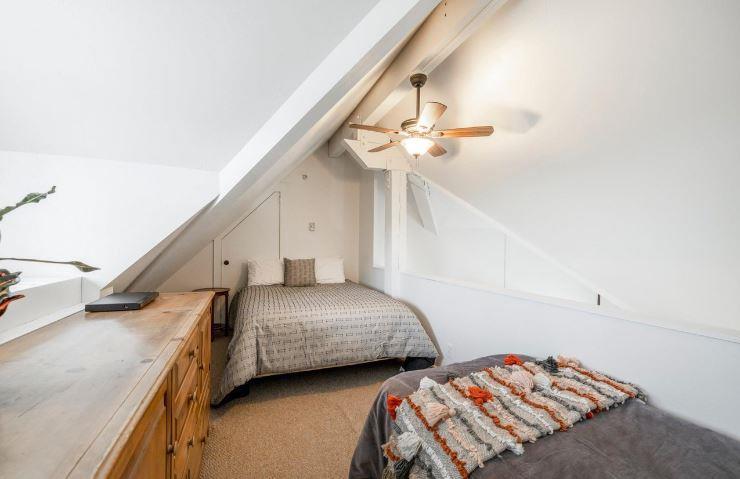 A cozy upstairs guest bedroom with a queen, twin, and ceiling fan makes Lodge at Mountain Village 303 perfect for families and friends — skiinskiout at Park City Resort.