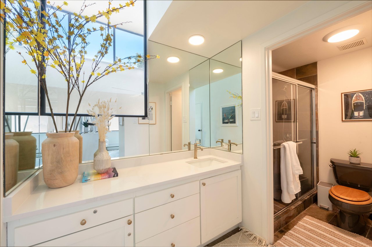 The ensuite bathroom at Park Avenue 299 is a bright and elegant retreat, featuring a spacious vanity, clean white finishes, and a walkin shower. Thoughtful touches like these make this Park City vaca
