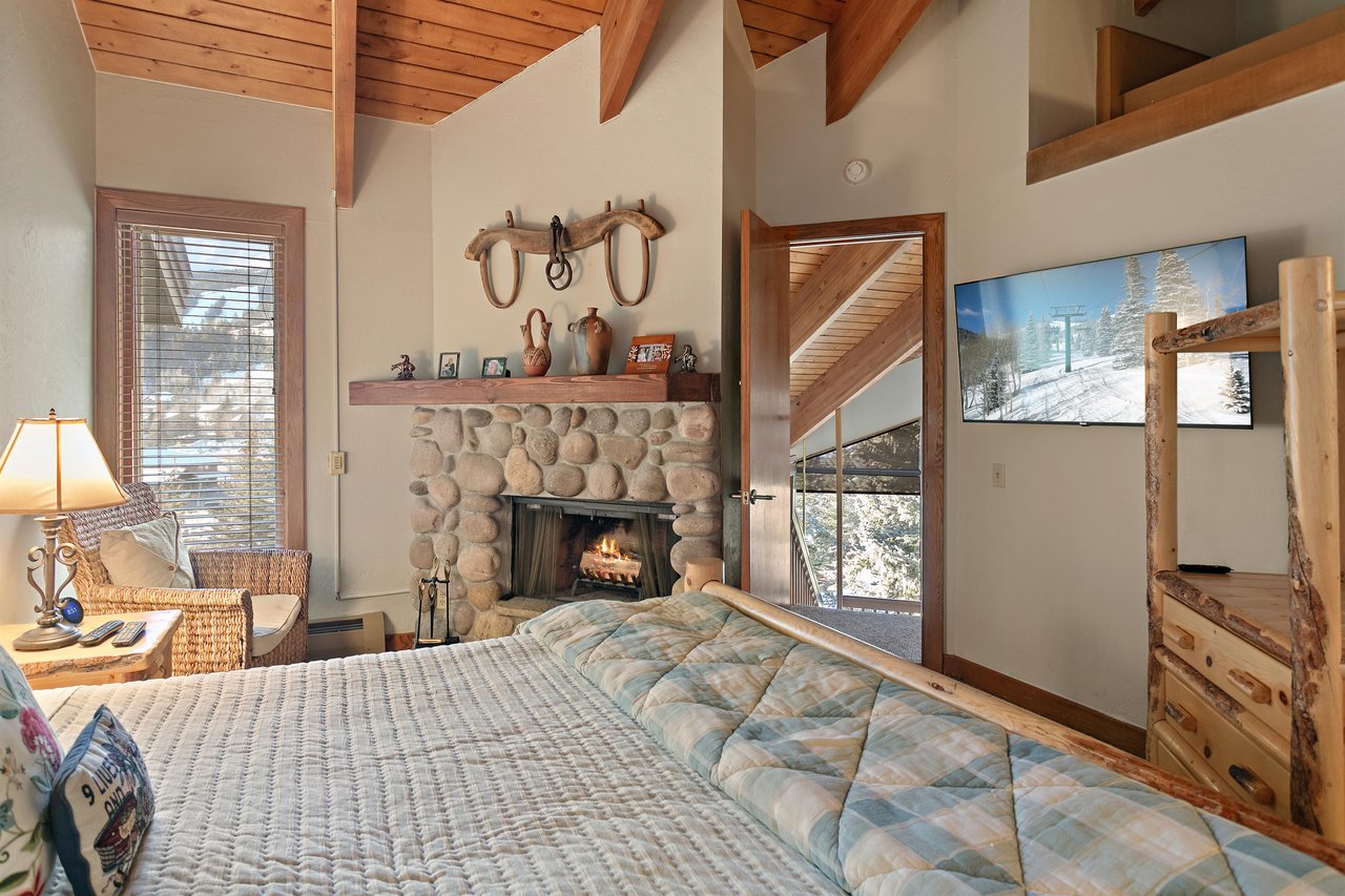 Fall asleep to the glow of a stone fireplace and wake up to breathtaking mountain views in the king bedroom at 1296 Pinnacle, one of Park Citys most soughtafter lodging destinations.