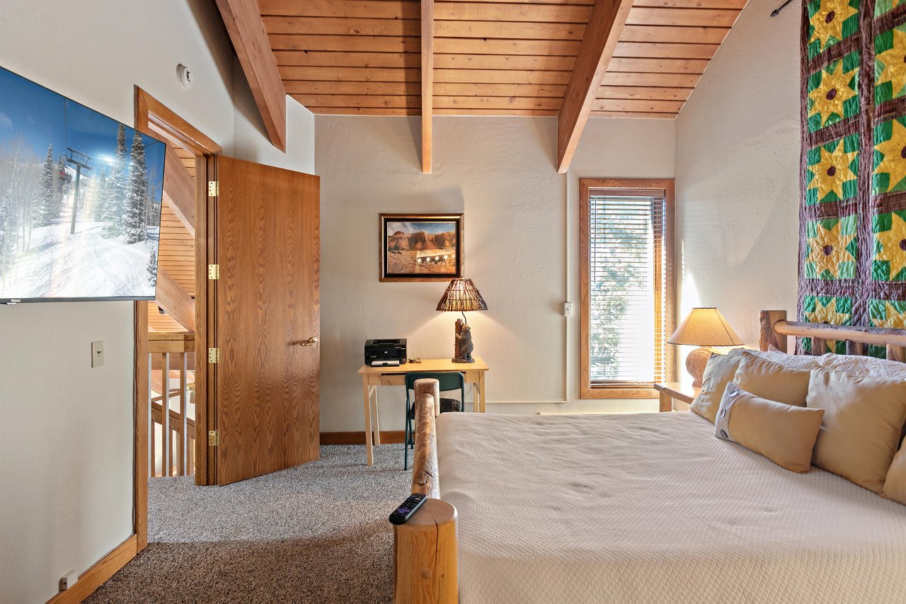 Natural light and warm wood accents set the tone in this relaxing bedroom at 1296 Pinnacle, one of Park Citys most soughtafter lodging options for a restful and rejuvenating mountain getaway.