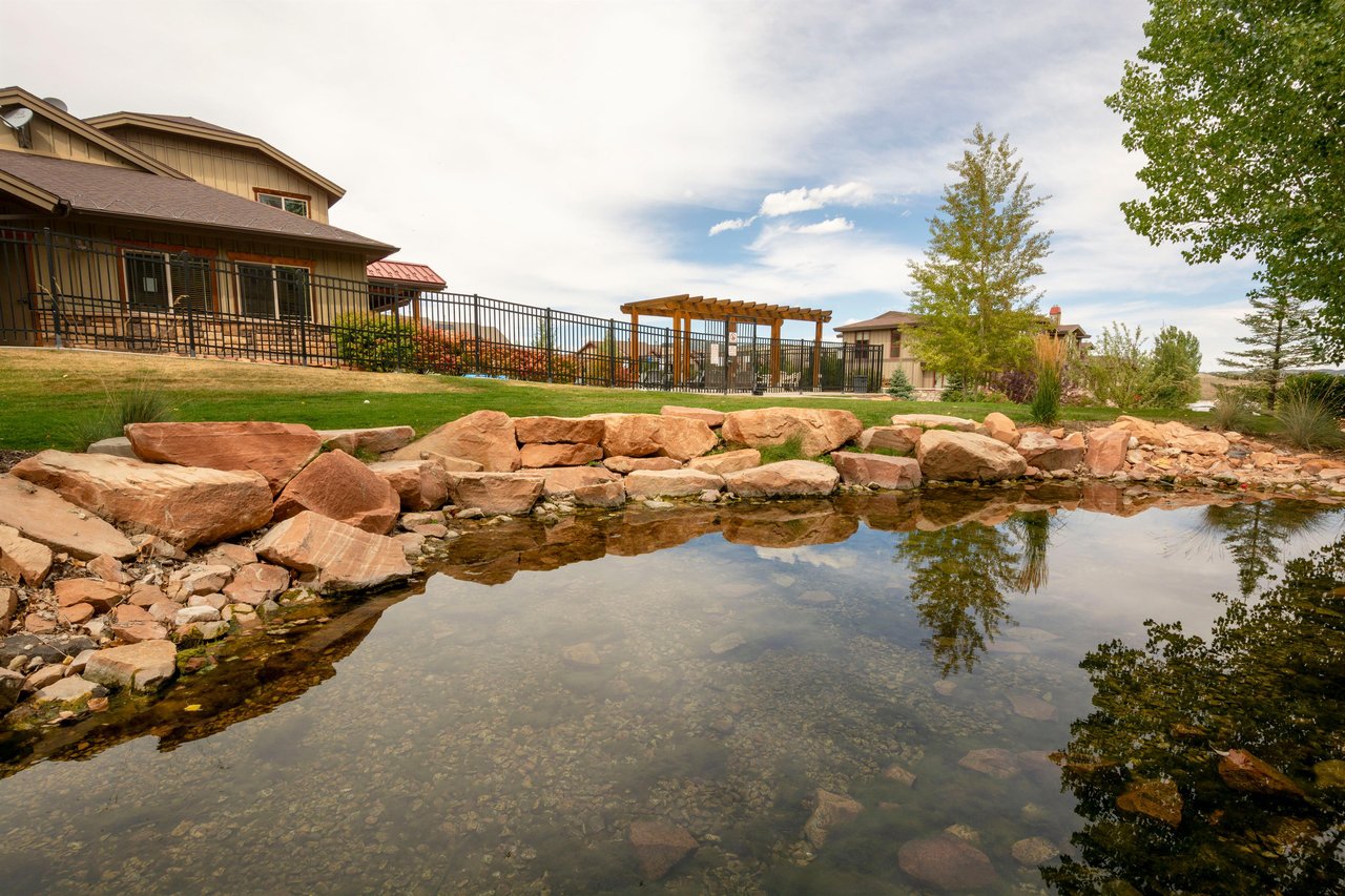 The beautifully landscaped grounds at Bear Hollow feature a serene pond and outdoor gathering spaces, adding to the resortlike atmosphere of this Park City vacation rental community.
